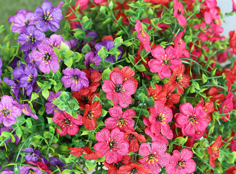Vibrant purple and pink petunias densely blooming in a green leafy planter.