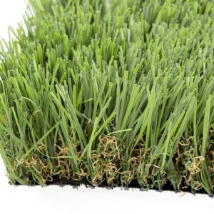 Close-up of dense green artificial turf blades with curled beige root filaments at the edge.