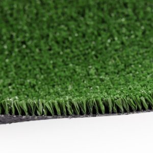 Close-up of artificial turf with green synthetic blades, showing the carpet edge and black backing