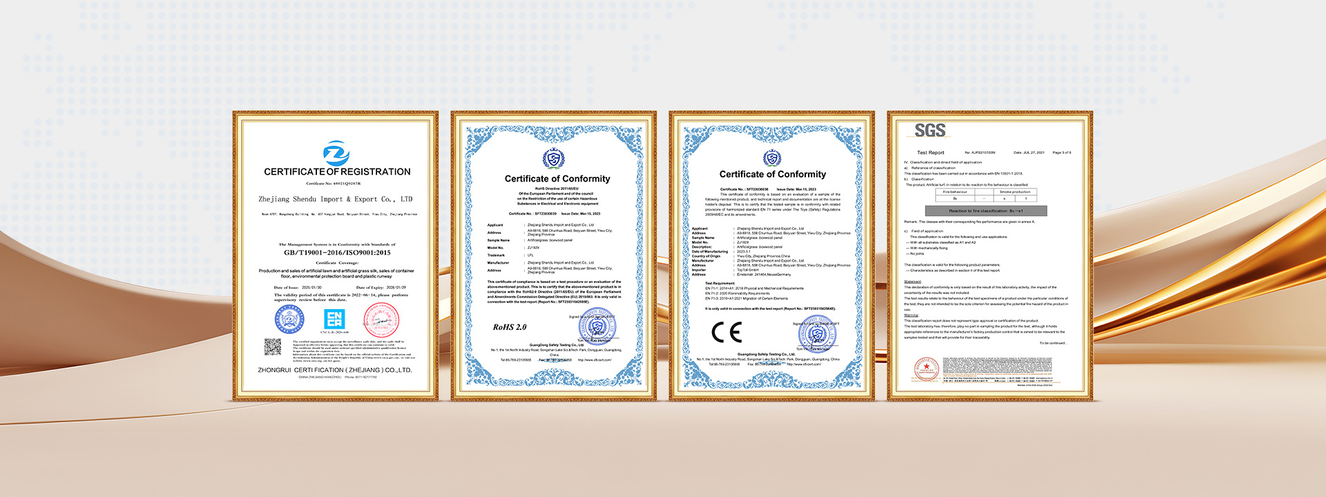 Four framed certificates lined up in a row on a light beige backdrop with gold frames, in a studio setting.