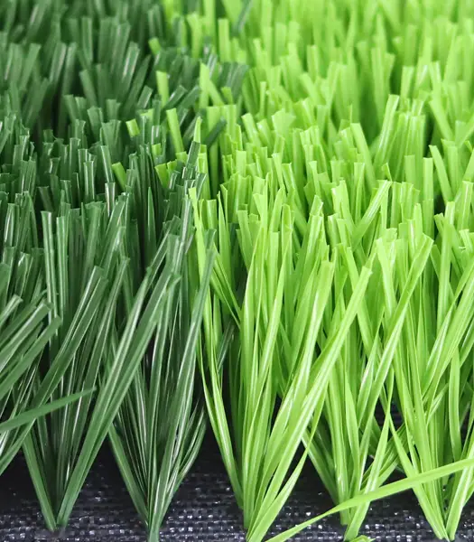 Close-up of vibrant green artificial grass blades standing upright from a dark backing.